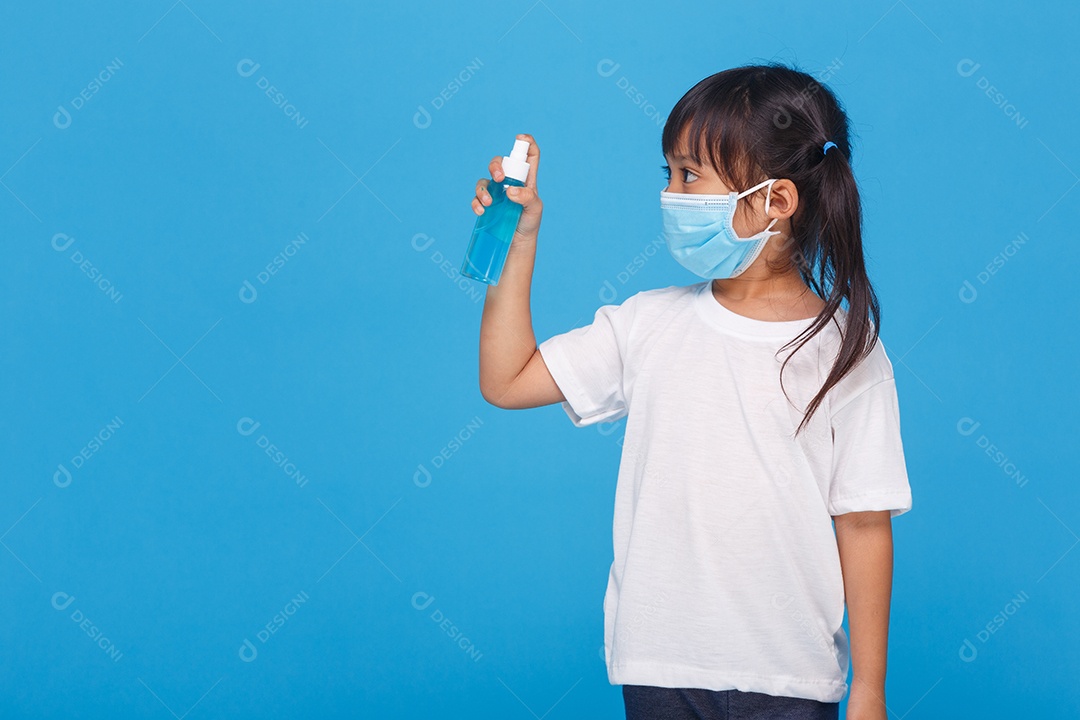 Linda garota asiática usando uma máscara e lavando as mãos com álcool
