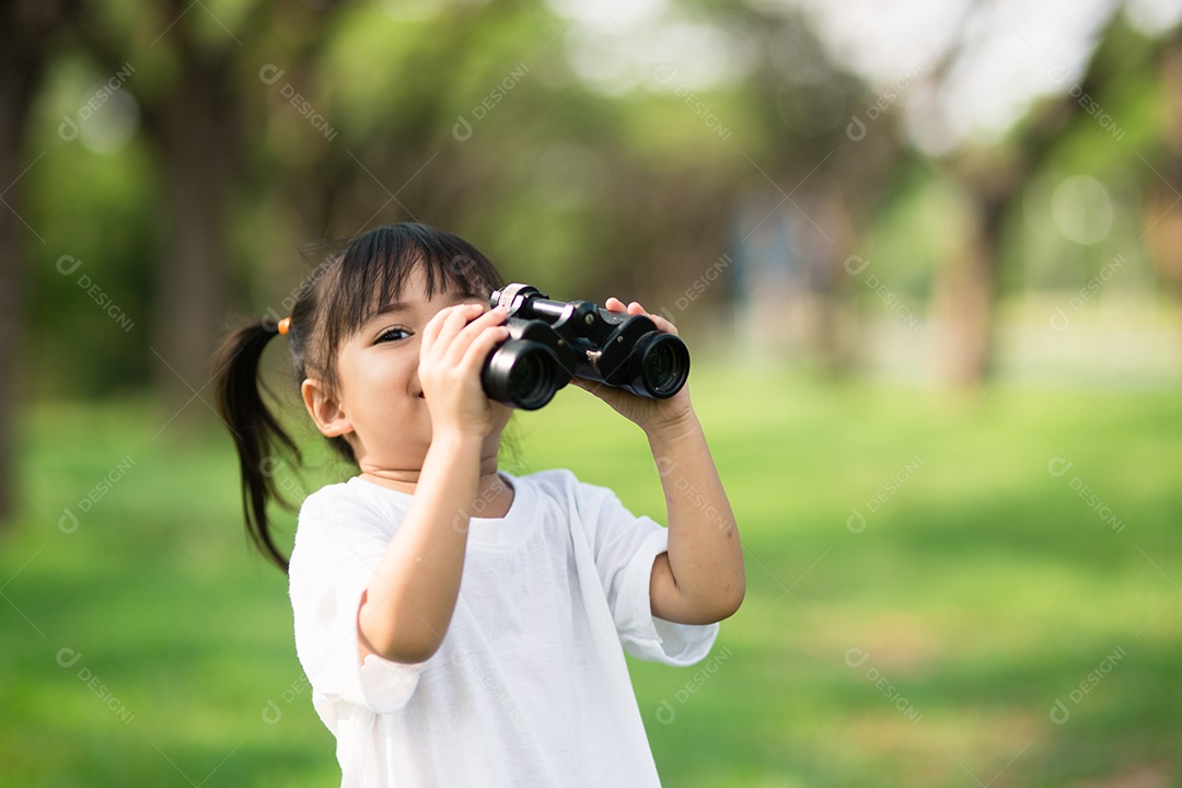 Menina criança feliz brincando com binóculos. explorar e conceito de aventura