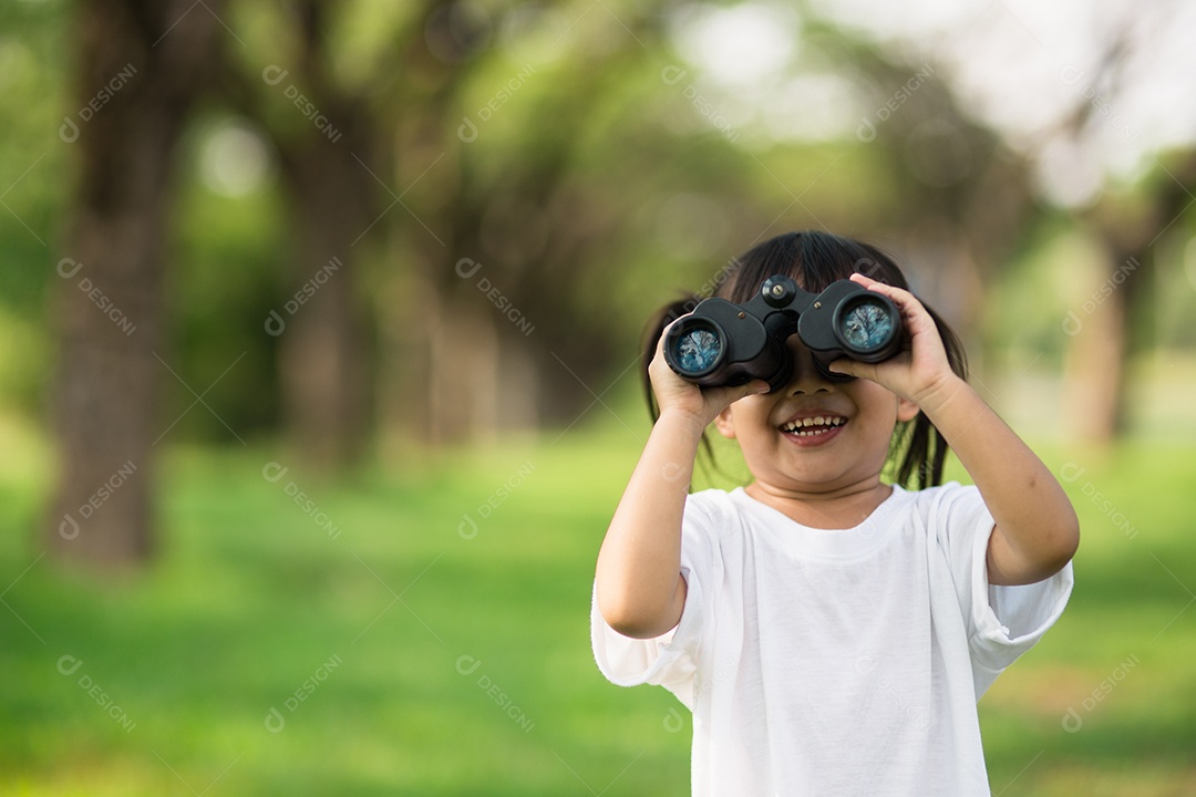 Menina criança feliz brincando com binóculos. explorar e conceito de aventura