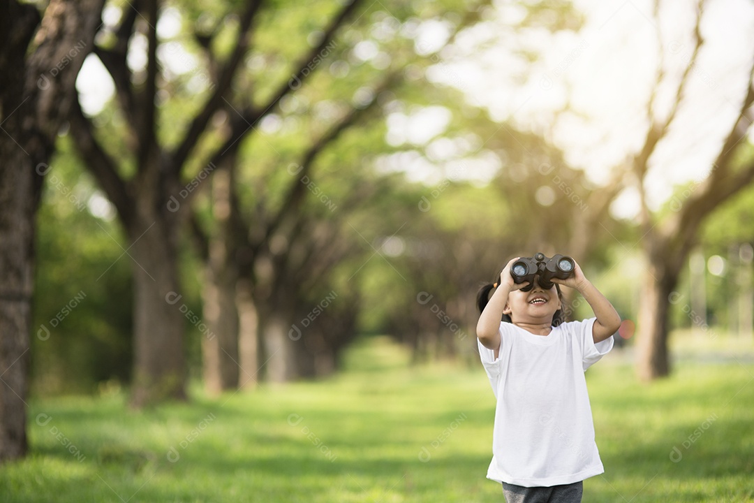 Menina criança feliz brincando com binóculos. explorar e conceito de aventura