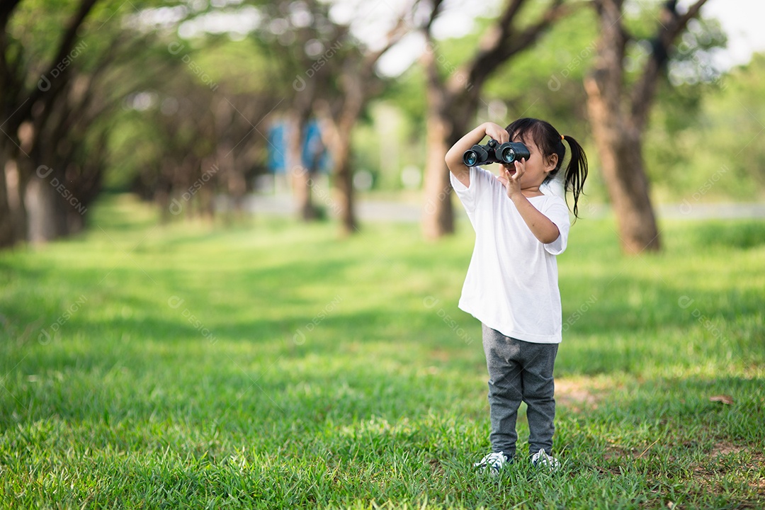 Menina criança feliz brincando com binóculos. explorar e conceito de aventura