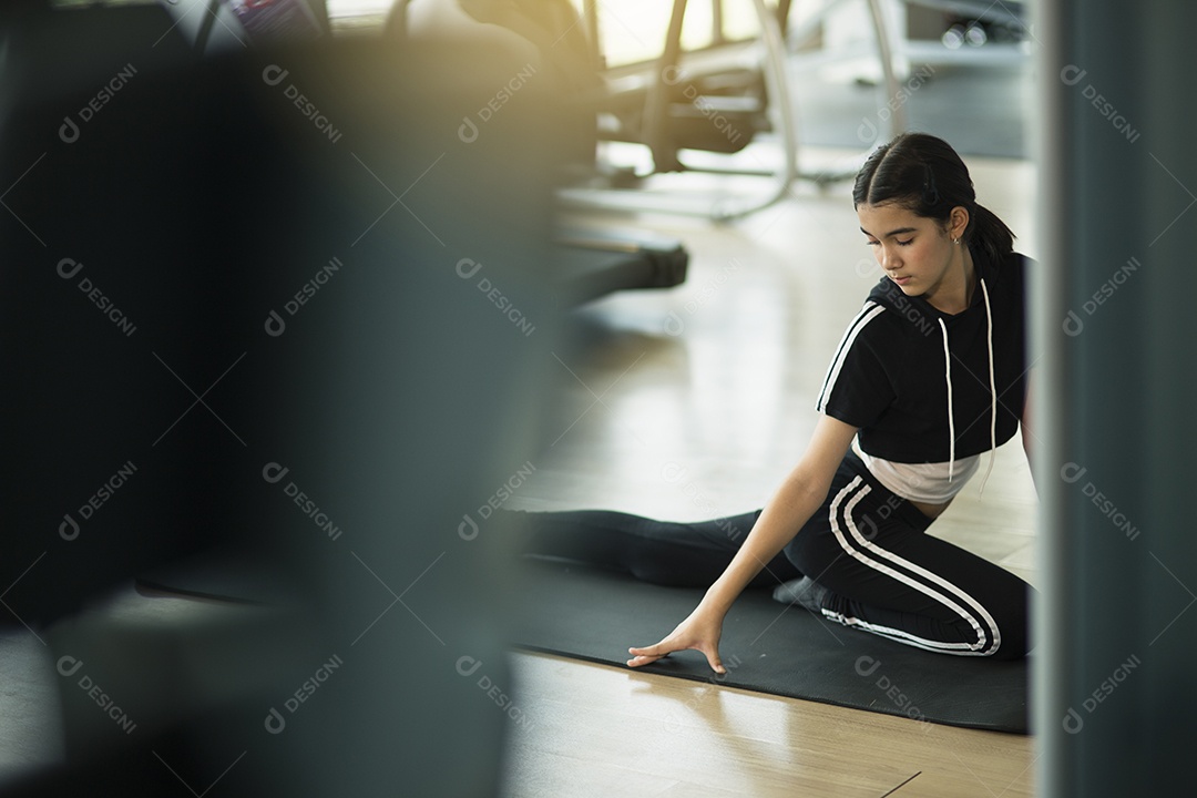 Menina bonita se aquecendo e fazendo algumas flexões na academia