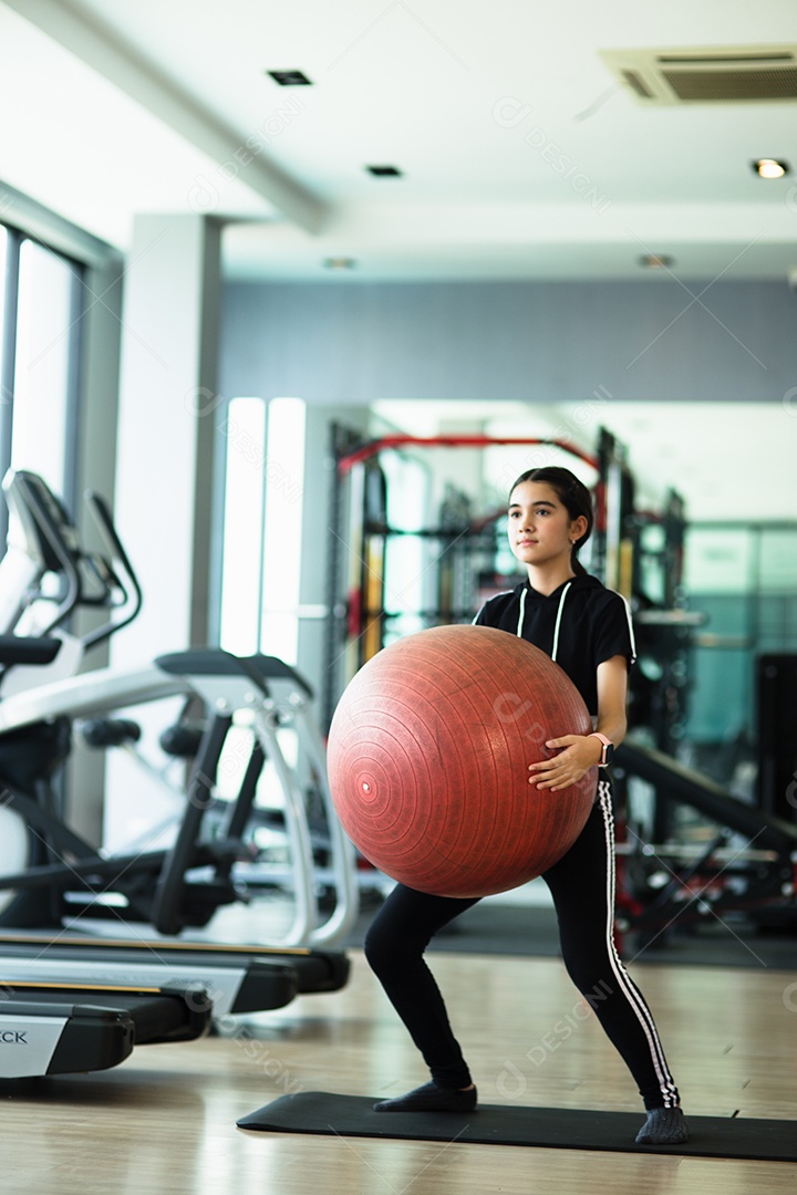 Mulher jovem e bonita desportiva. Garota malhando com bola de fitness