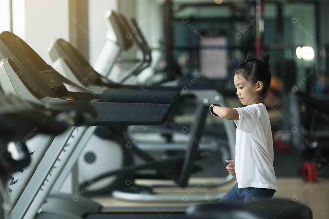 Menina usando bicicleta ergométrica no ginásio. Fêmea de fitness usando bicicleta