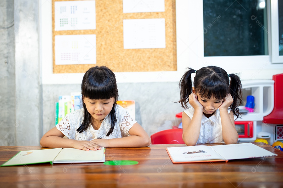 Retrato de alunas olhando para a lição de leitura de página