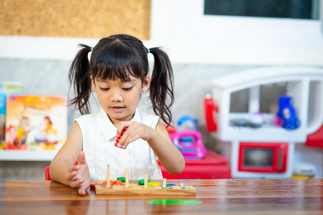 Criança menina jogando brinquedos de madeira
