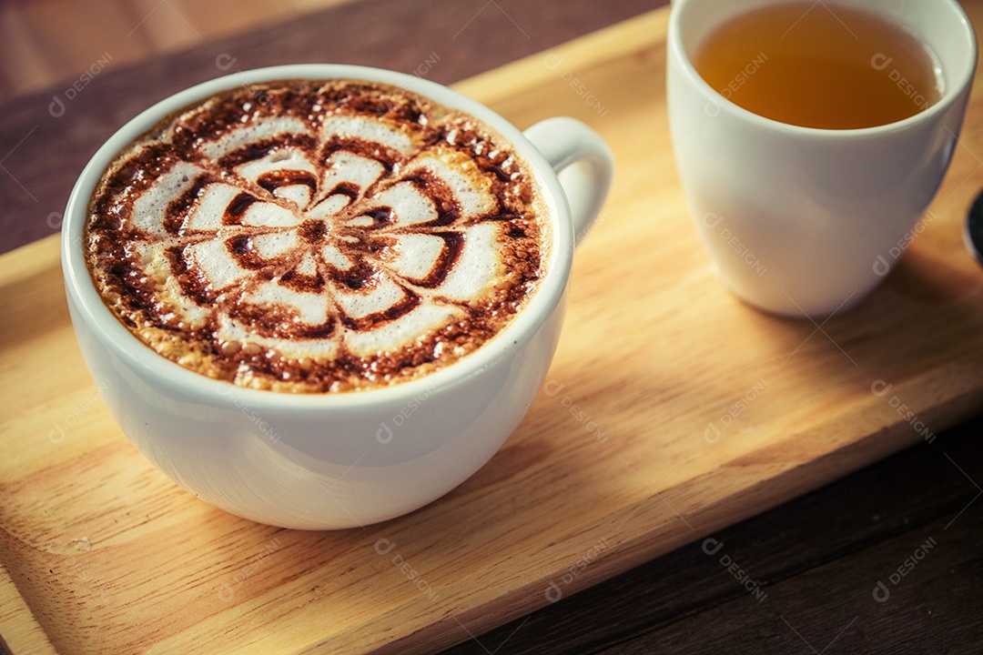 Café com leite na mesa de madeira com xícara de chá