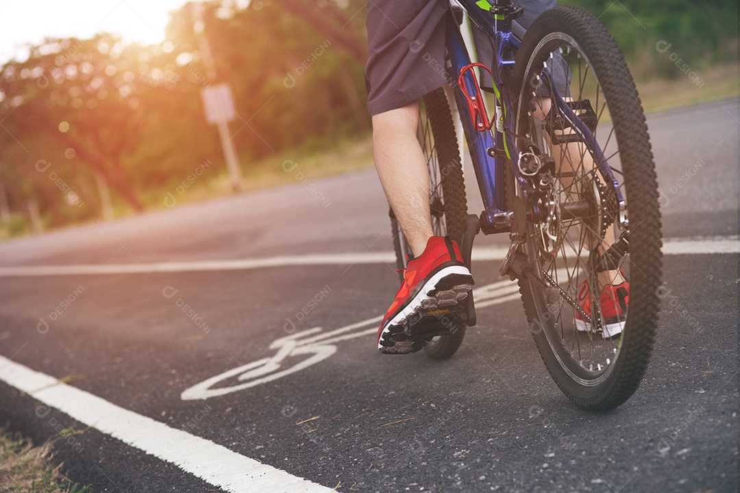 Ciclista andando de bicicleta em uma estrada aberta para o pôr do sol.