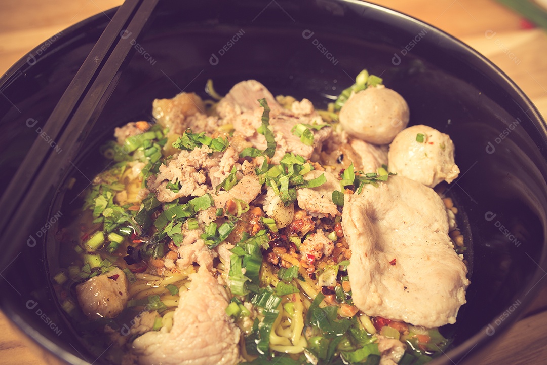 Tigela de macarrão com legumes na mesa de madeira. macarrão delicioso