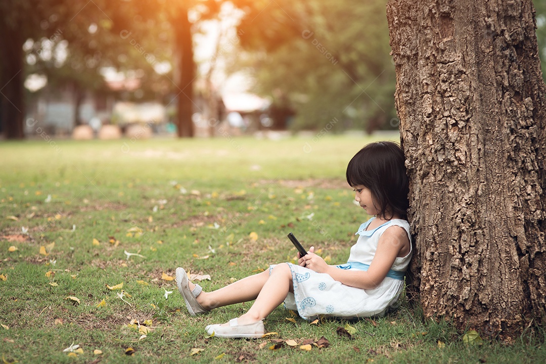 Menina com um telefone celular no parque