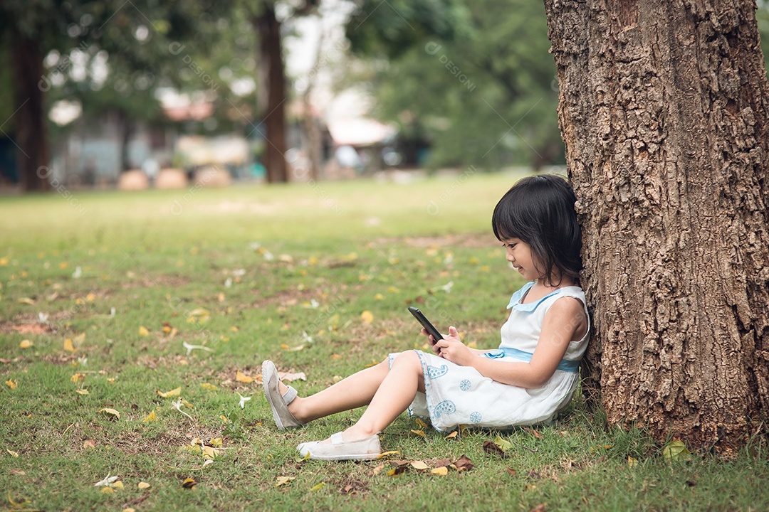 Menina com um telefone celular no parque