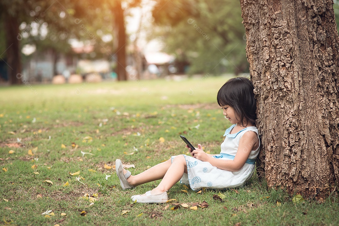 Menina com um telefone celular no parque
