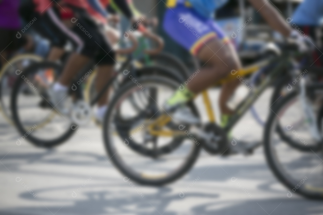 Detalhe da roda de bicicleta com ciclista embaçada.