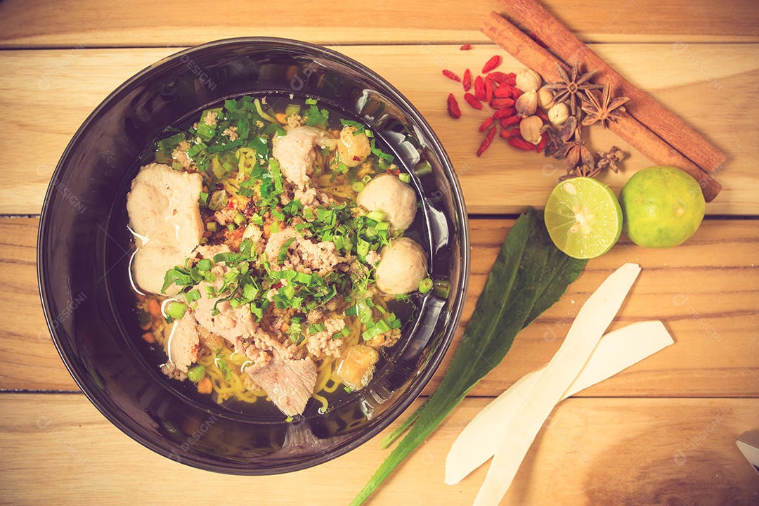 Tigela de macarrão com legumes e ovo cozido na taboa de madeira.