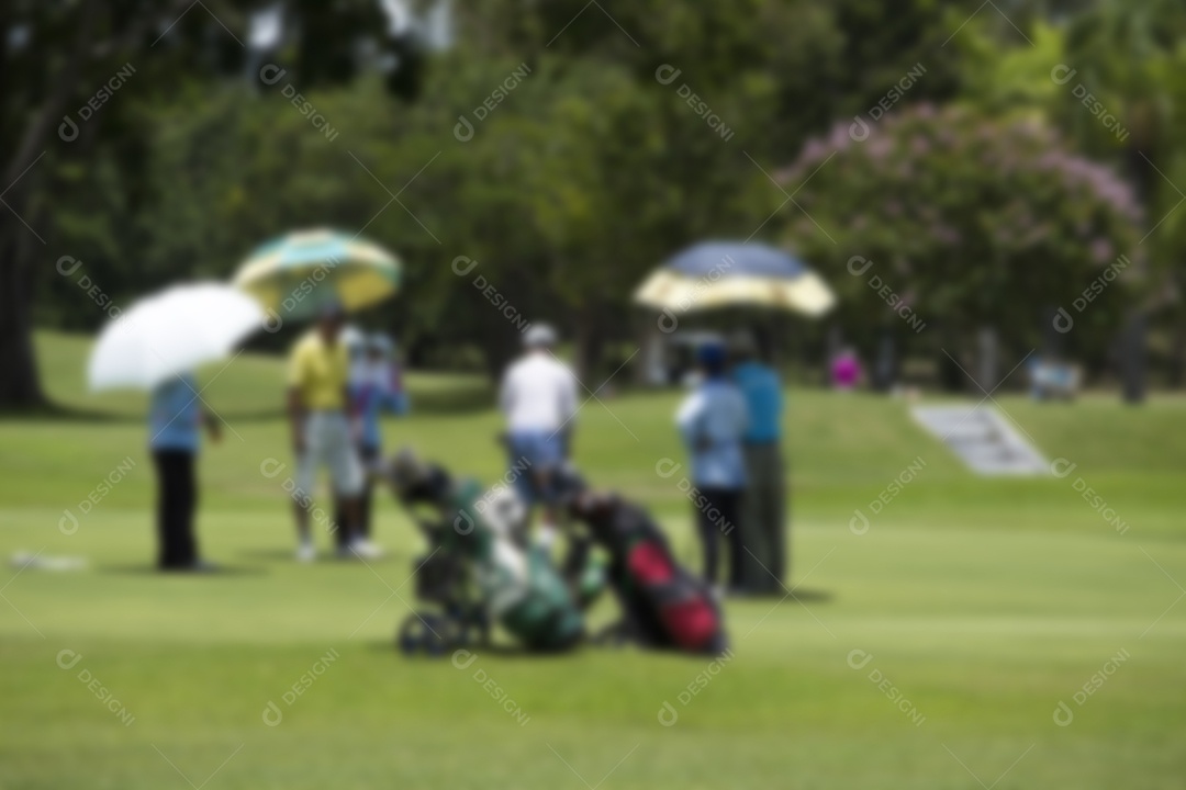 Jogadores de golfe embaçados atingem um campo de golfe arrebatador no verão.