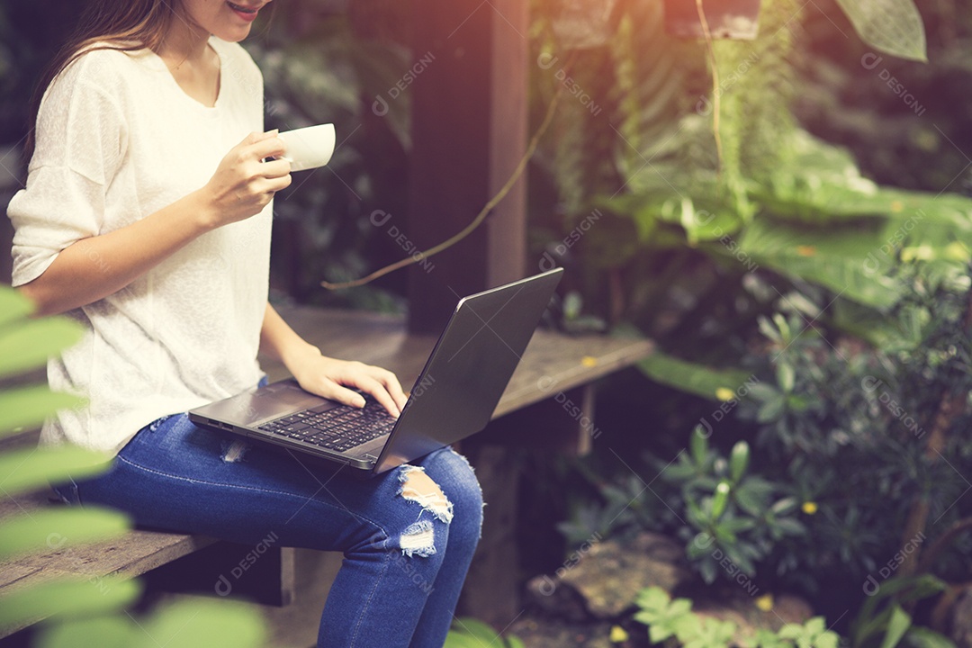 Beautiful hipster woman using laptop in cafe while drinking coffee.