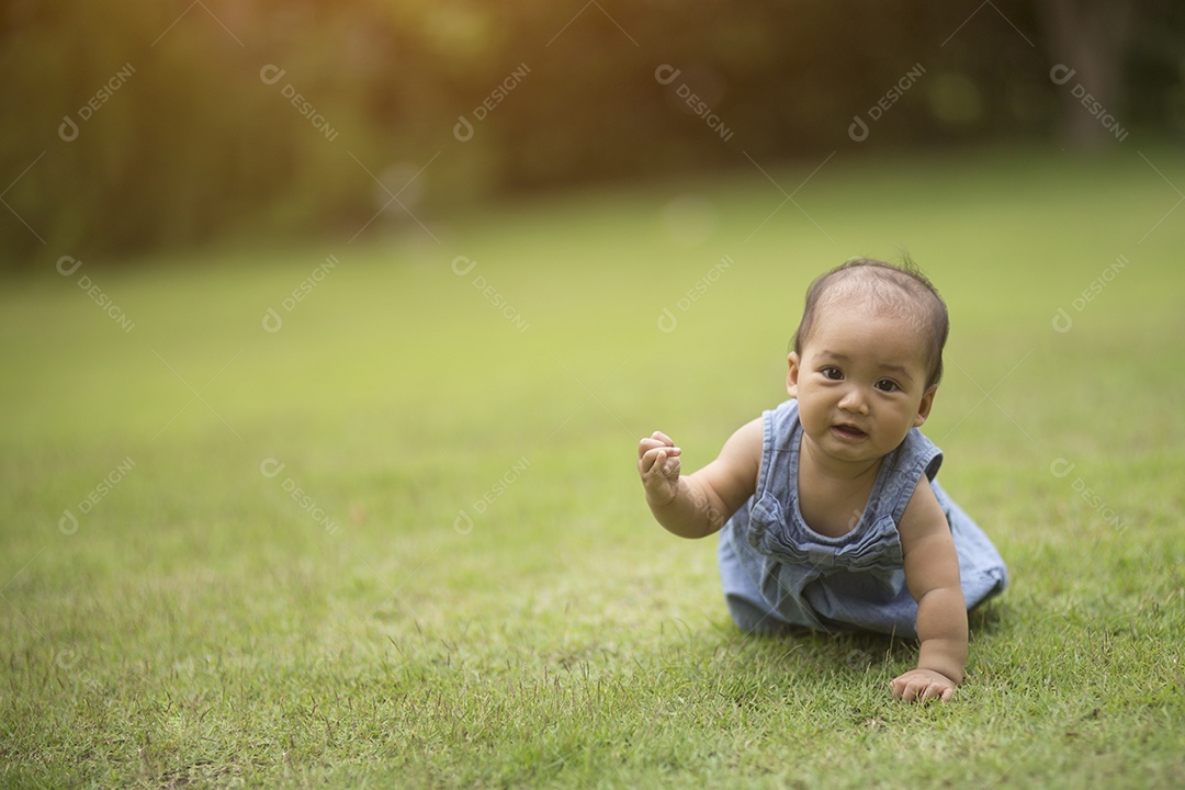 Bebê fofo rastejando na grama cor vintage.