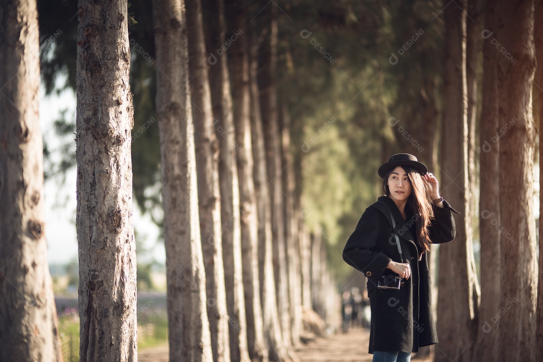 Mulher feliz e elegante hipster tirando foto com câmera fotográfica.