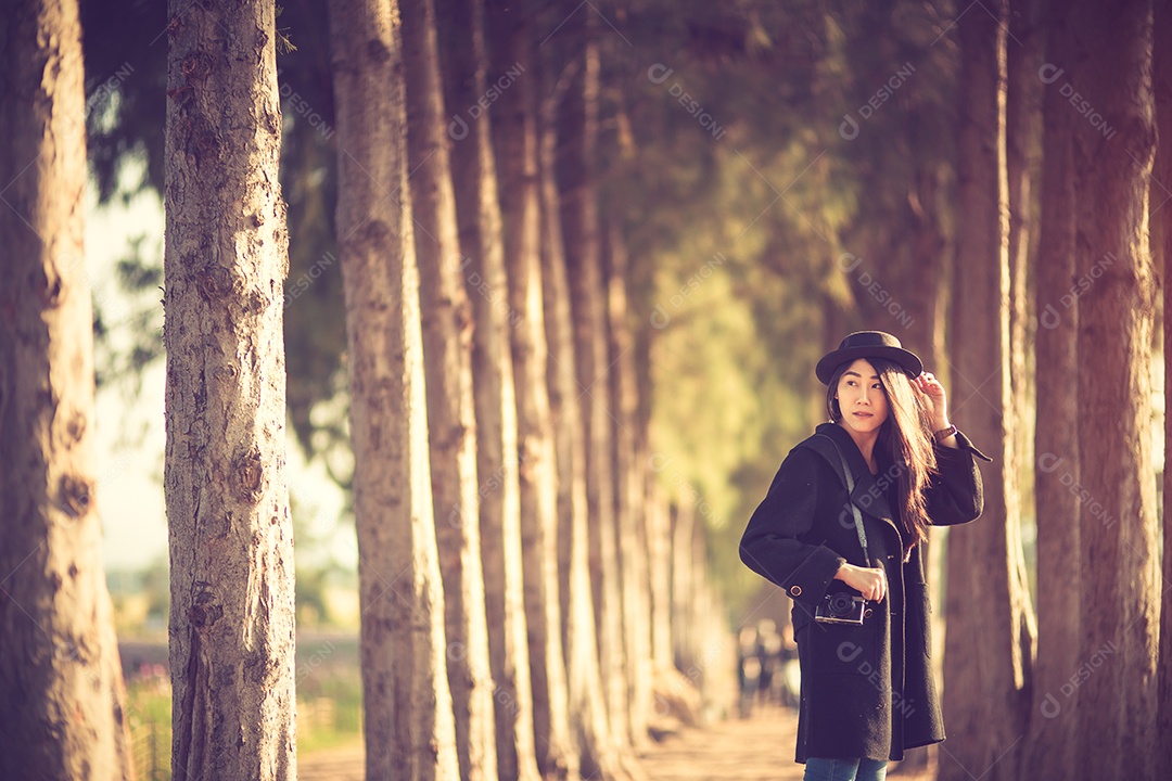 Mulher feliz e elegante hipster tirando foto com câmera fotográfica.
