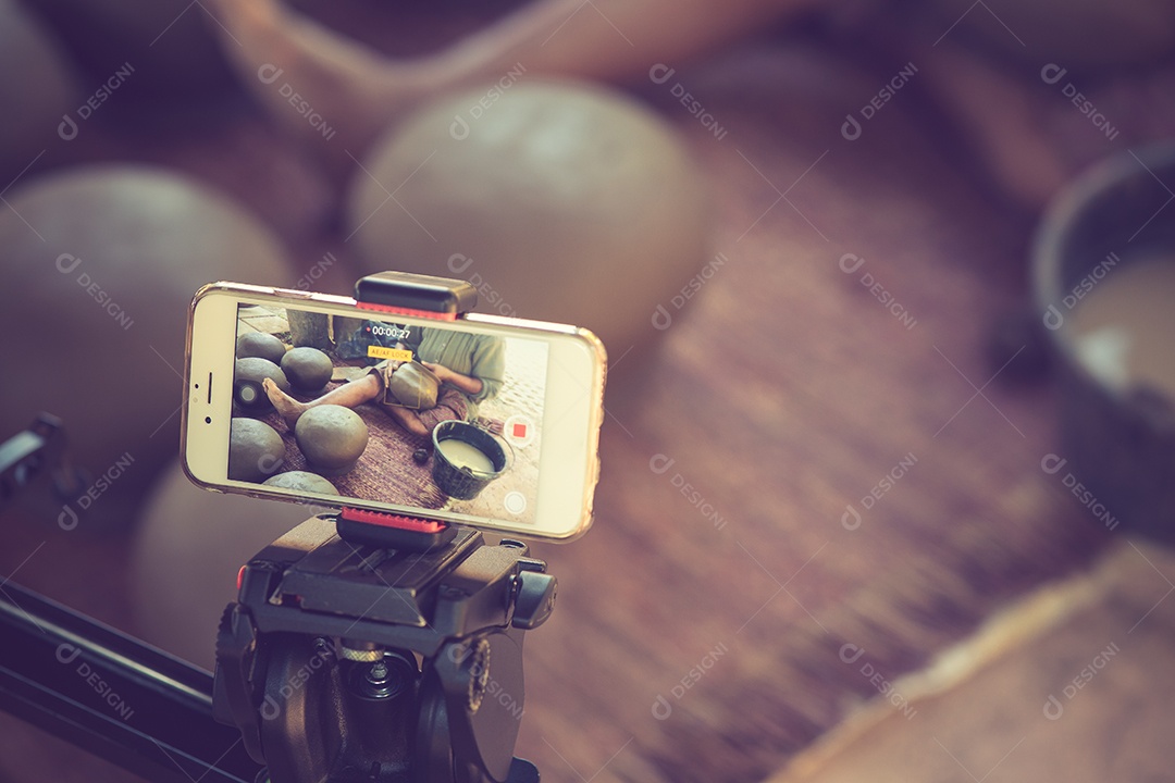 Tirando foto por smartphone em um tripé cor vintage.