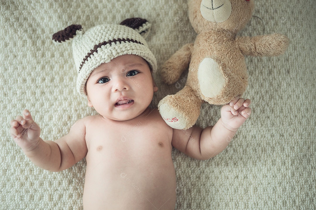 Bebê recém-nascido em um cobertor com um ursinho.