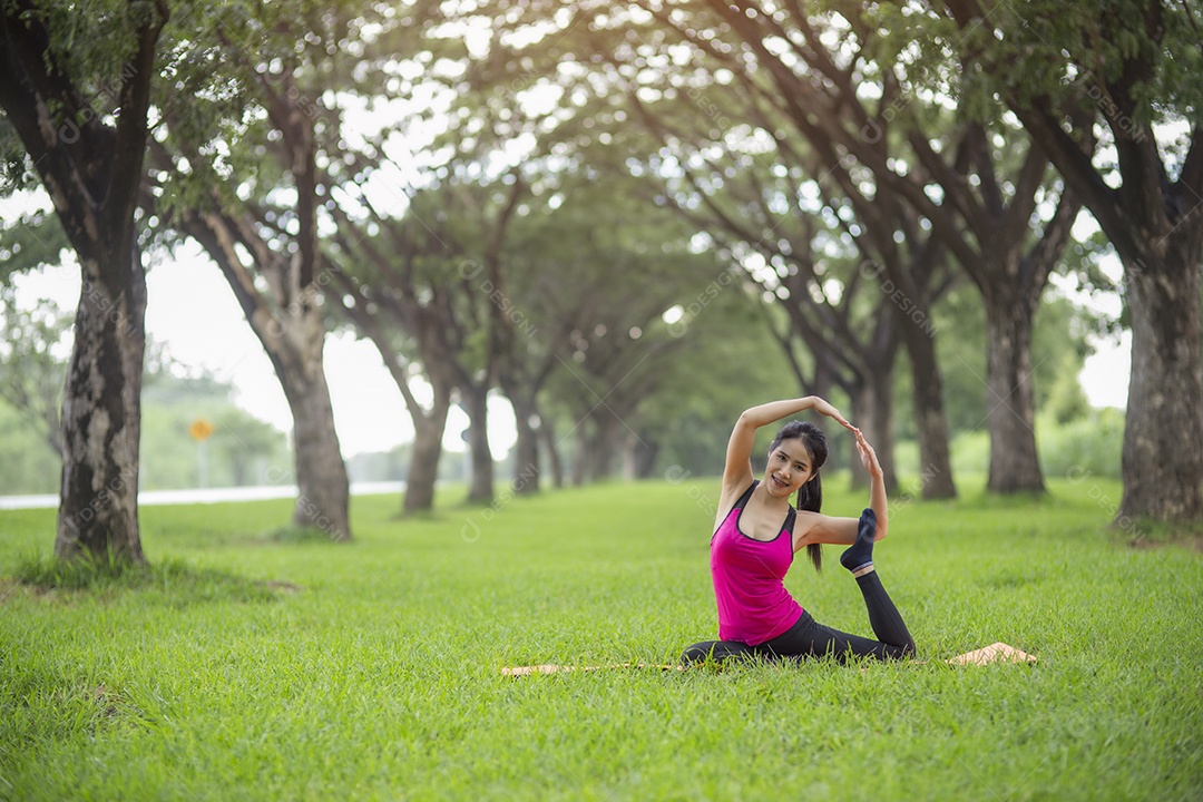 Jovem mulher praticando ioga no parque.