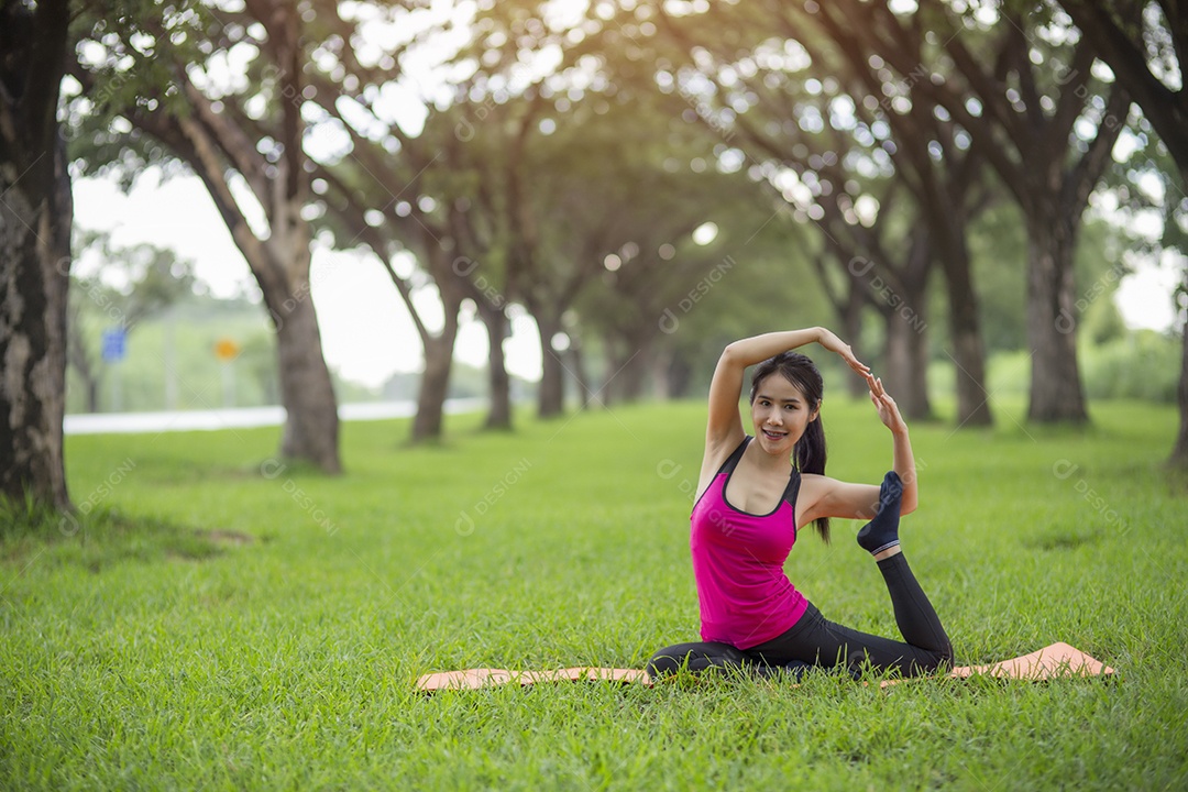 Jovem mulher praticando ioga no parque.