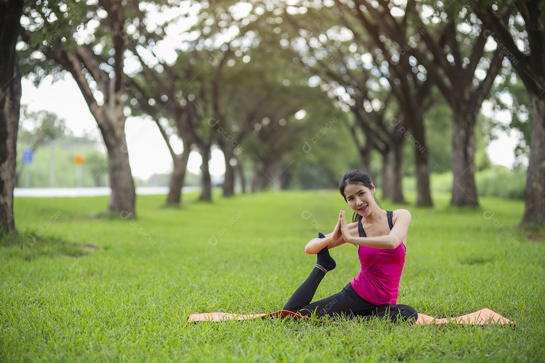 Jovem mulher praticando ioga no parque.