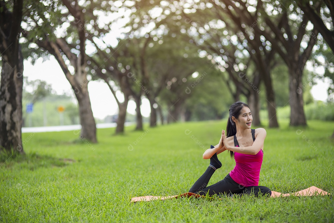 Jovem mulher praticando ioga no parque.