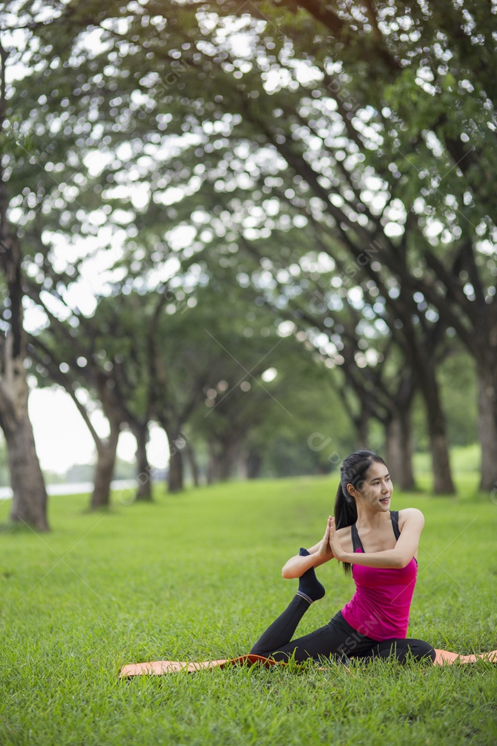 Jovem mulher praticando ioga no parque.