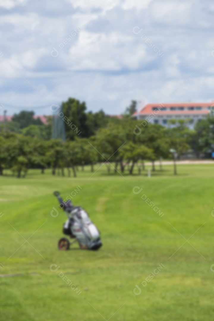 Jogadores de golfe embaçados atingem um campo de golfe arrebatador no verão sob o sol.