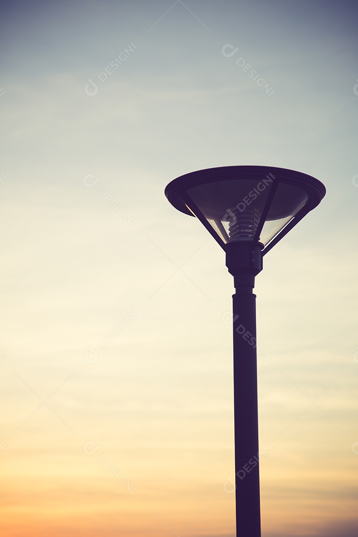 Lâmpada de rua, poste com luzes acesas durante o dia com fundo.