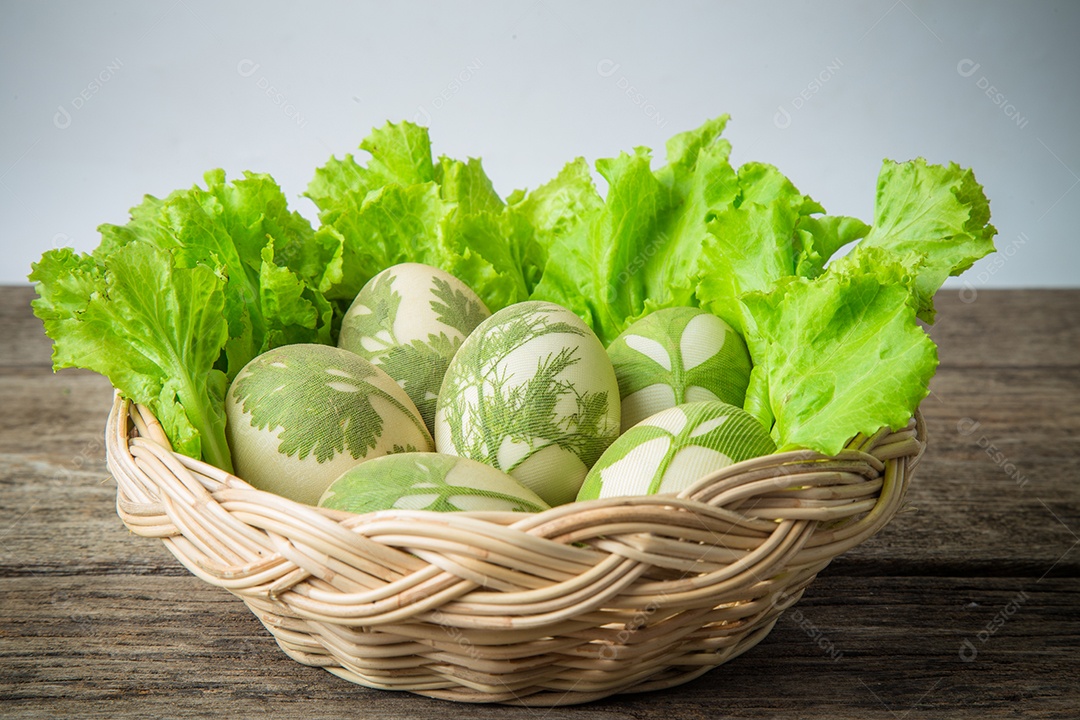 Ovos de Páscoa na cesta em pranchas de madeira rústicas.