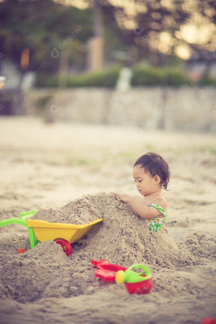 Bebê brincando na praia perto da cor vintage do mar.