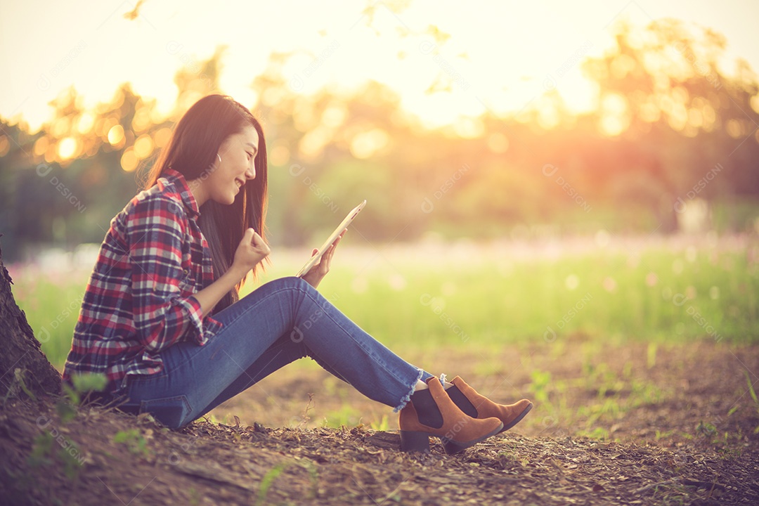 Mulher eufórica procurando emprego com um laptop em um parque urbano