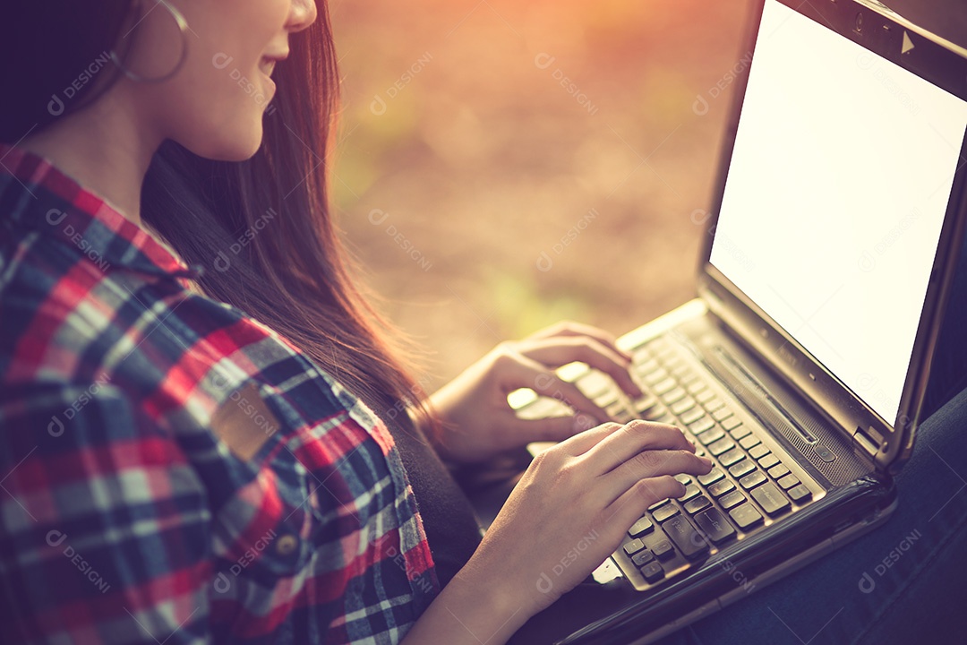 Mulher eufórica procurando emprego com um laptop em um parque urbano
