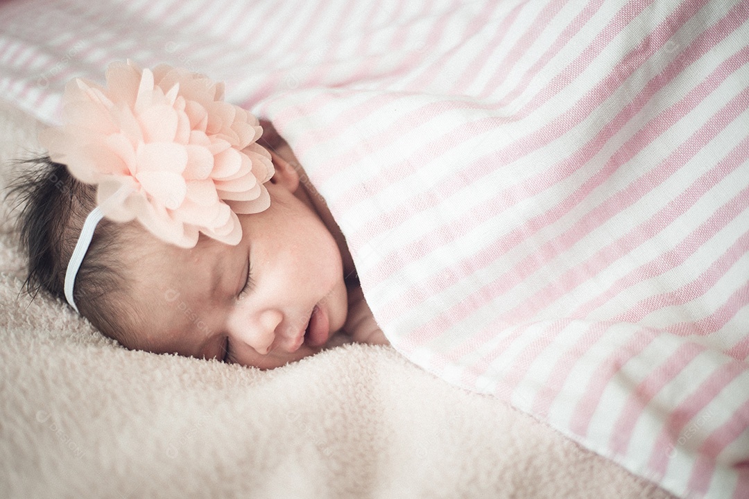 Linda garota recém-nascida dormindo em um fundo rosa