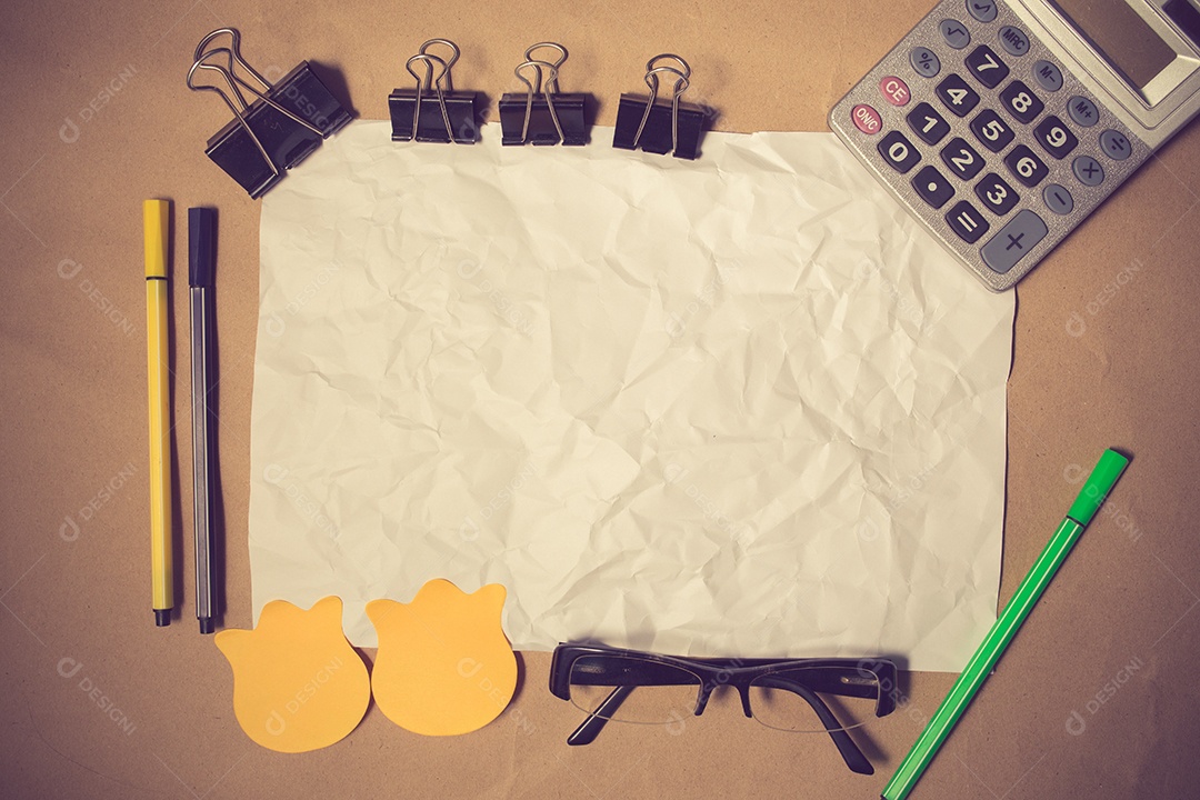 Tabela do designer bagunçado com nota em branco e ferramentas