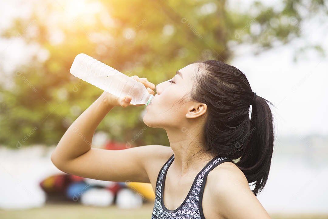 Água potável de mulher jovem e bonita após o exercício