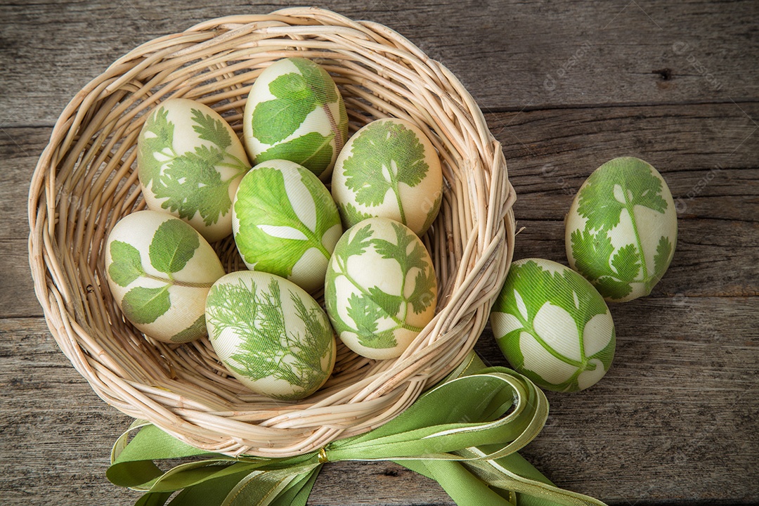 Ovos de Páscoa na cesta na cor vintage de pranchas de madeira rústica