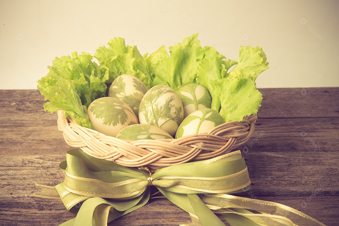 Ovos de Páscoa na cesta na cor vintage de pranchas de madeira rústica