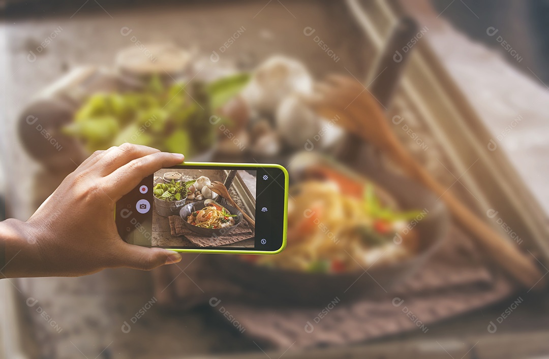 Segurando o smartphone para captura, tire uma foto de prato de comida