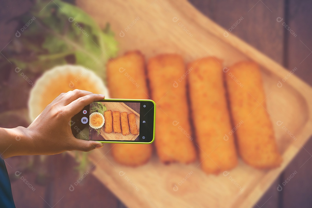 Segurando o smartphone para captura, tire uma foto de prato de comida