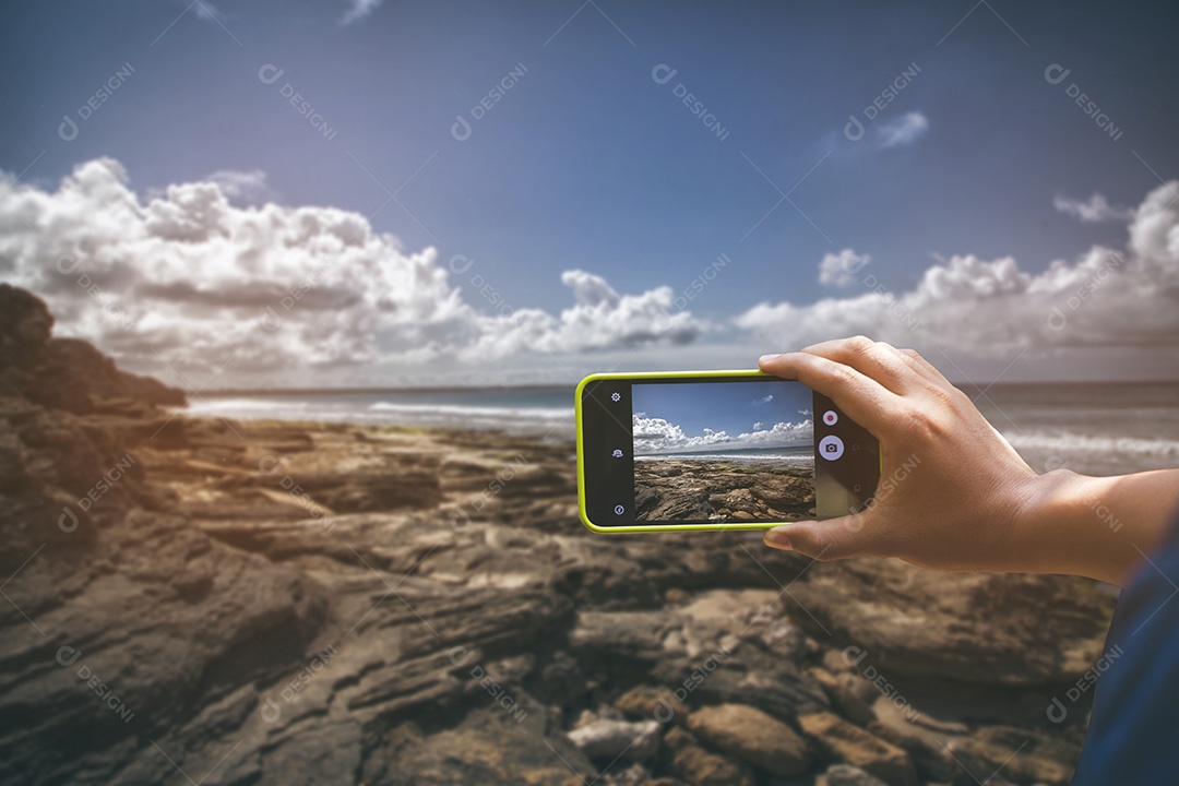 Segurando o smartphone para captura, tire uma foto de praia dia ensolarado mar