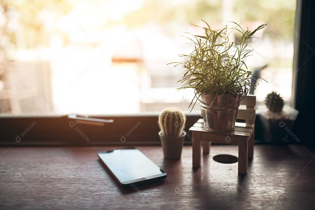 Mesa de madeira para cafeteria com smartphone e planta.