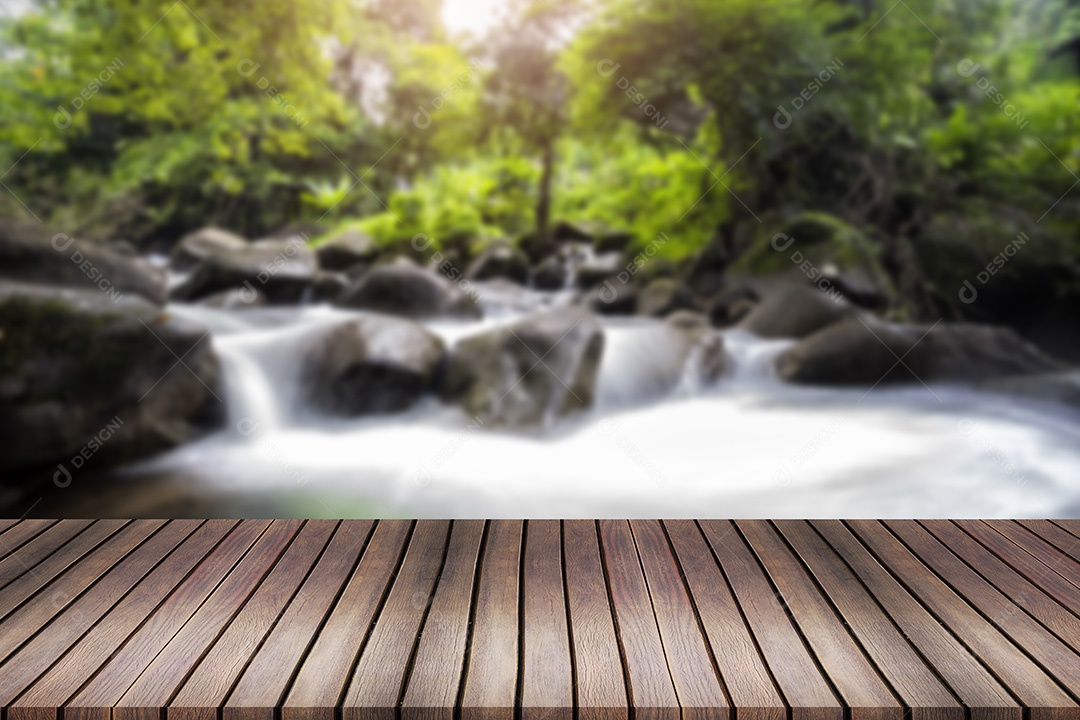 Cachoeira em um riacho de montanha. Em primeiro plano uma prancha de madeira