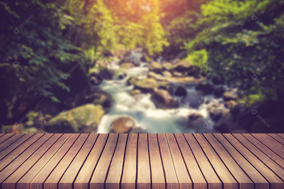 Cachoeira em um riacho de montanha. Em primeiro plano uma prancha de madeira