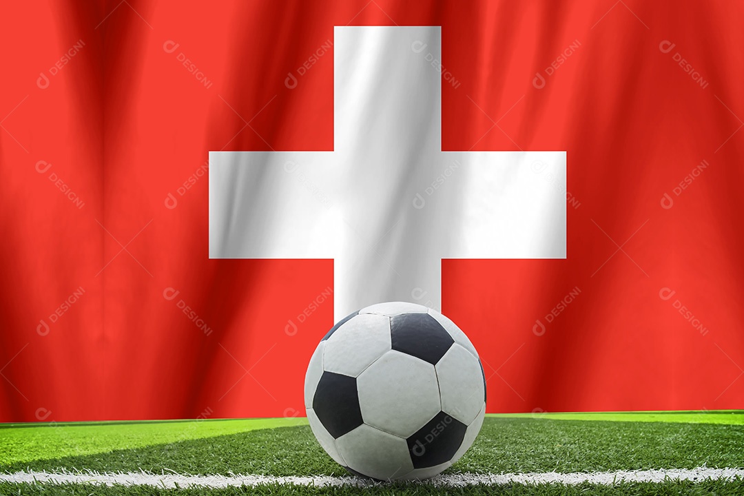 Bola de futebol e a bandeira nacional da Suíça estão na grama verde