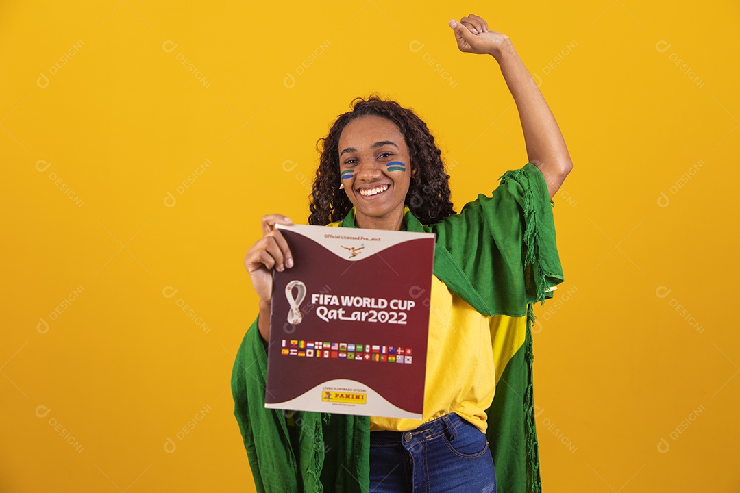 Linda mulher jovem brasileira segurando album da copa do mundo