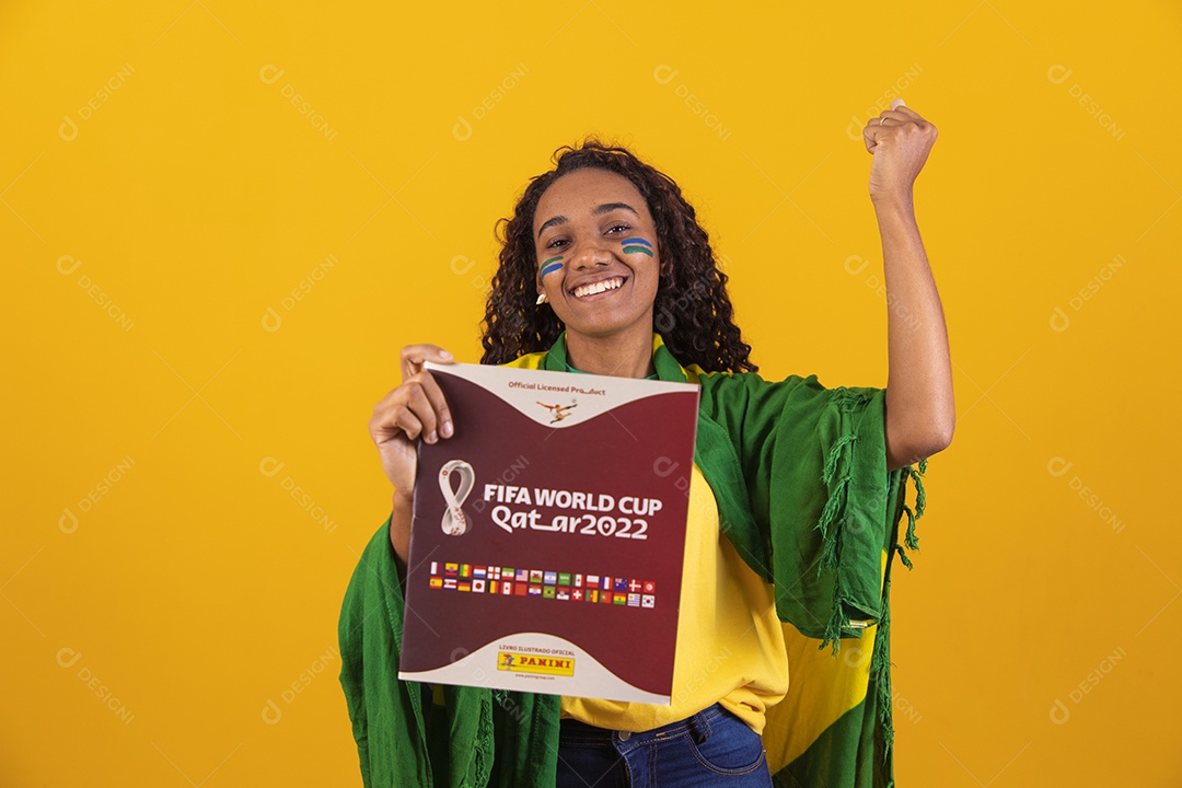Linda mulher jovem brasileira segurando album da copa do mundo
